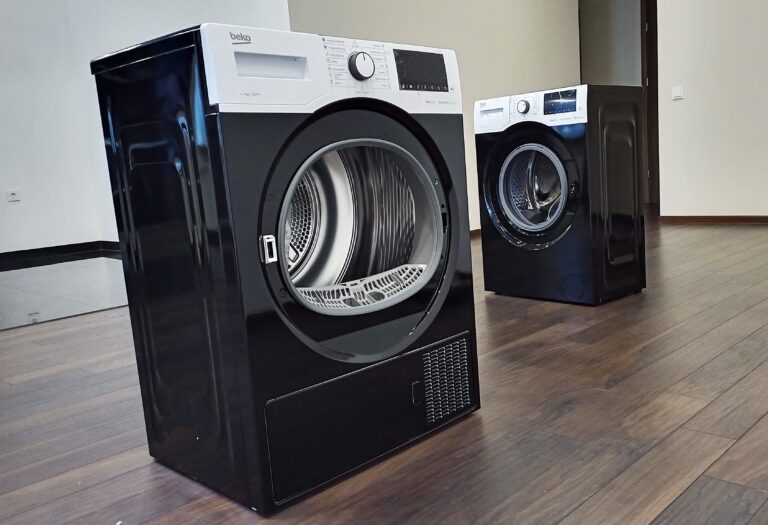 Kodumasinate kiletamine – mustaks kiletatud pesumasin ja kuivati tumedal puidust põrandal, TapeThat Tallinnas