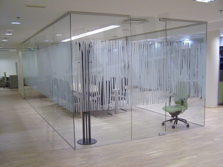 Suur klaasist koosolekuruum kontoris, mille klaasseinad on kiletatud vertikaalse mustriga mattklaasikilest privaatsusribadega