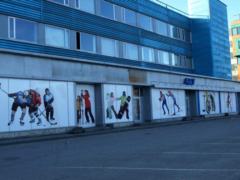 Spordipoe A&T vaateakende kiletamine, millele on paigaldatud täiskõrguses trükikiled erinevate talispordialade graafikaga