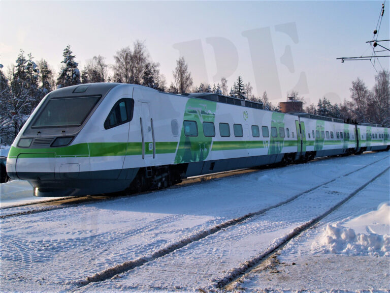 Pendolino rohevalge kiirrong talvisel raudteel, vagunid kaetud rohelist tooni kiletuse ja reklaamkleebistega – rongi kiletamine