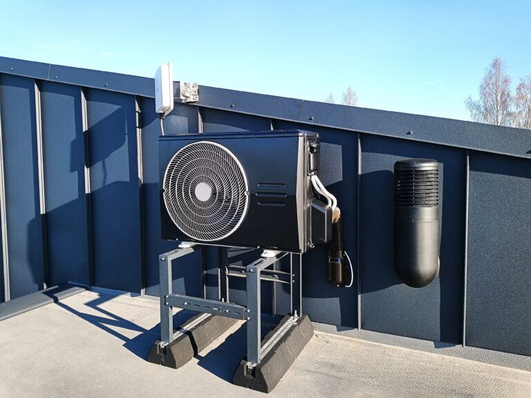 Katusele paigaldatud soojuspumba kiletamine, kaetud tumeda kilega sama tooniga kui hoone plekkfassaad